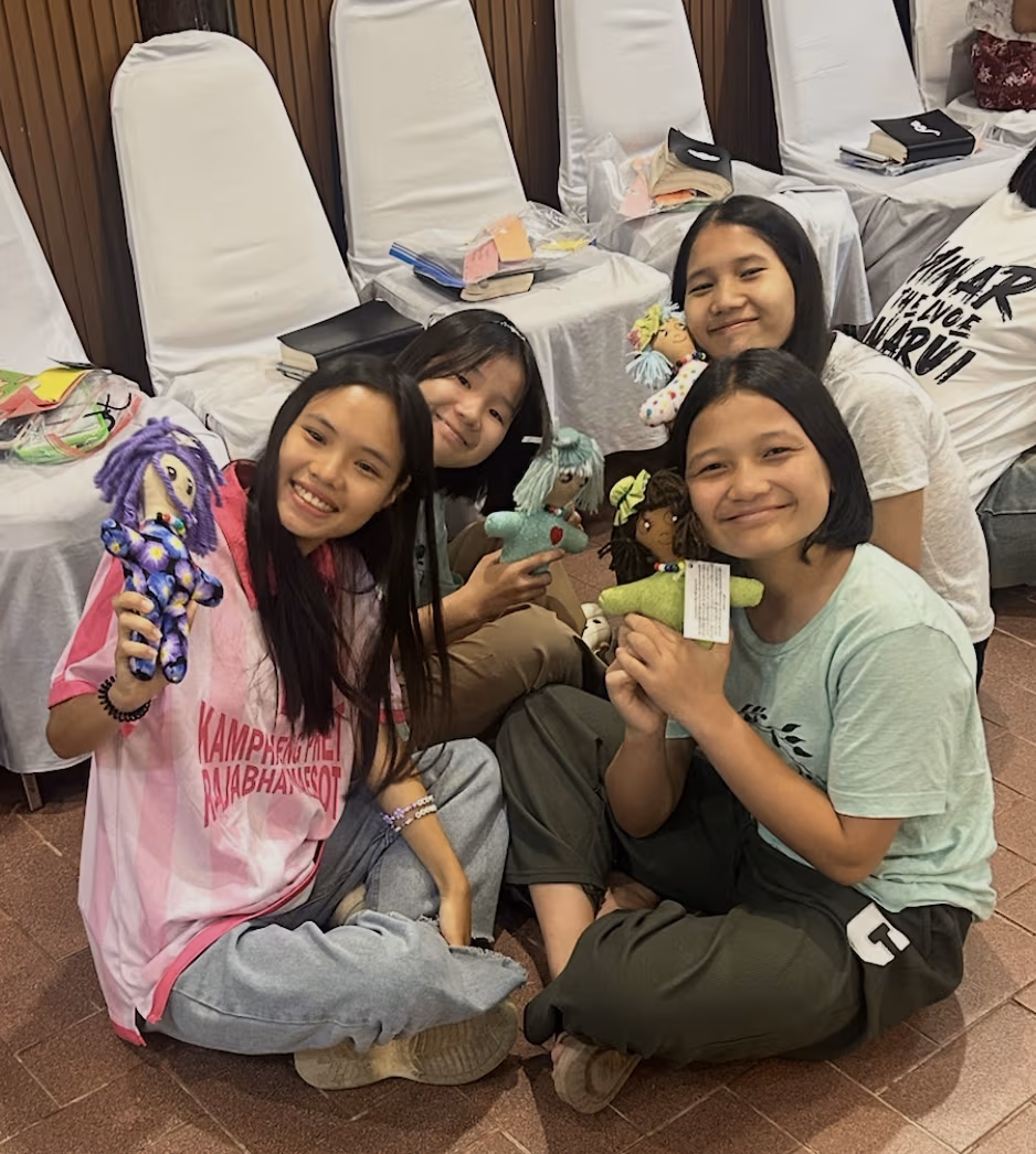 Girls practicing sharing the gospel with their dolls